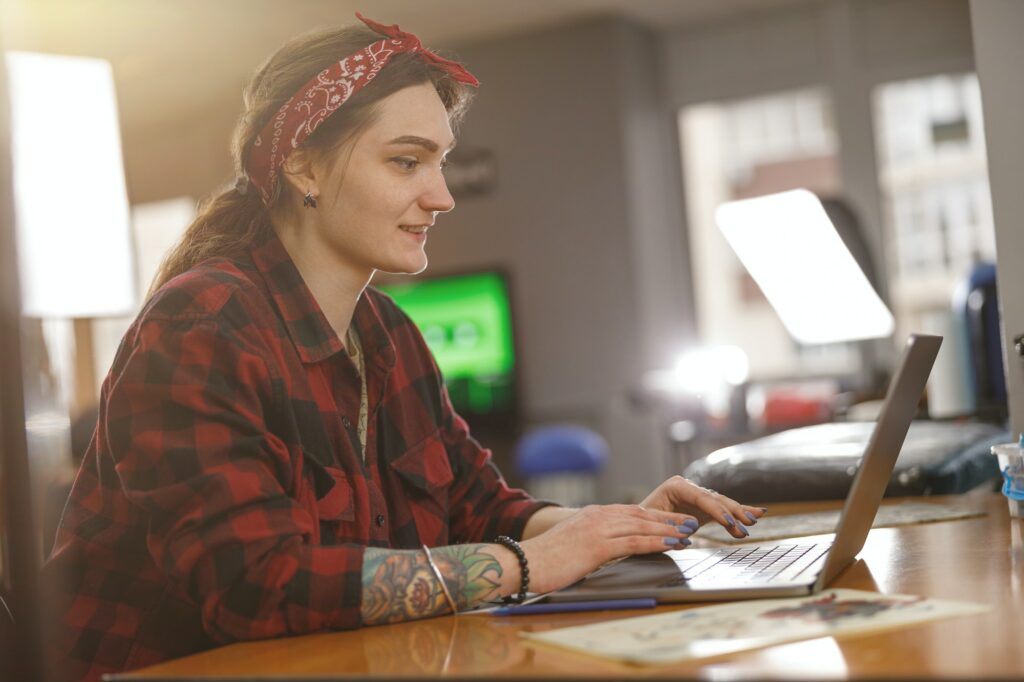 Tattoo artist working on laptop in office